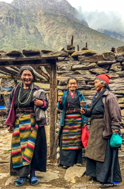 Three women standing in front of a typical home in the main path that runs through Sama village (3550m). They are wearing the typical Tibetan-style Nubri dress that most women over about 30 wear. They are on their way to the eye screening clinic.
 